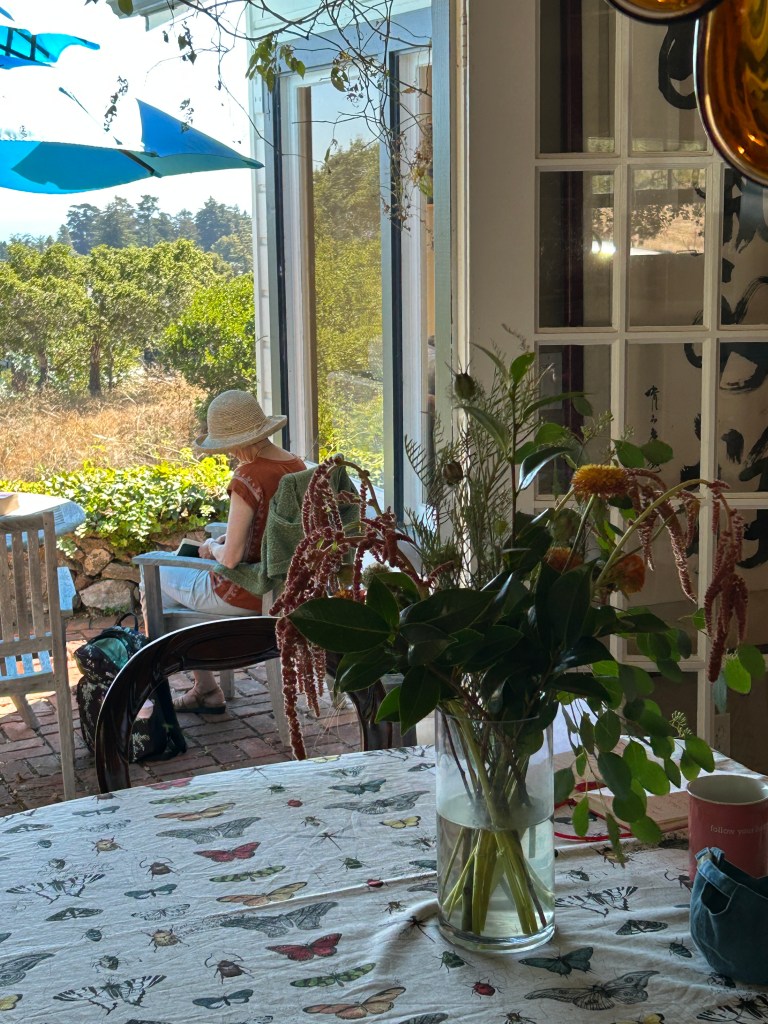 author sitting in the garden writing in a notebok
